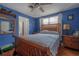 Relaxing bedroom featuring blue walls, wood accents, and a comfortable-looking bed at 2613 Upton S St, Gulfport, FL 33711