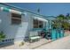 Sweet blue house with awning windows, colorful plants, and a cozy sitting area on the front porch at 2613 Upton S St, Gulfport, FL 33711