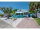 Quaint beach house boasts a brick path, xeriscaping and cheerful turquoise porch, creating a welcoming curb appeal at 2613 Upton S St, Gulfport, FL 33711
