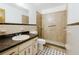 This bathroom has a tiled walk-in shower, a mirrored vanity and black and white tiled floors at 3213 W Ivy St, Tampa, FL 33607