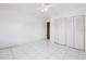 This bedroom features tile floors, bi-fold closet doors, and a modern ceiling fan at 3213 W Ivy St, Tampa, FL 33607