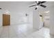 Open living room connected to the kitchen and entry door, featuring tile flooring and ceiling fan at 3213 W Ivy St, Tampa, FL 33607