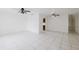 Bright living room featuring ceramic tile flooring, ceiling fans and a glimpse into kitchen at 3213 W Ivy St, Tampa, FL 33607