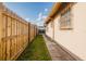 Side yard showing a fence, grass, and a walkway next to the property under a blue sky at 3213 W Ivy St, Tampa, FL 33607