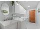 Well-lit laundry room with washer, dryer, sink, and ample cabinet space at 3309 Westmoreland Dr, Tampa, FL 33618