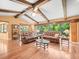 Bright living room featuring wood floors, exposed wood beams, and a large window overlooking lush greenery at 3309 Westmoreland Dr, Tampa, FL 33618