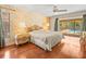 Comfortable main bedroom with plush bedding, ceiling fan, and sliding glass doors leading to a screened pool area at 3309 Westmoreland Dr, Tampa, FL 33618
