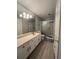Bathroom featuring a neutral color palette, a shower with glass doors, and a large vanity with ample counter space at 404 Lennox W Rd # 404, Palm Harbor, FL 34683