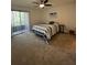 Bedroom with carpet flooring, a ceiling fan, balcony access through sliding doors, and a comfy bed at 404 Lennox W Rd # 404, Palm Harbor, FL 34683