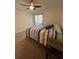 Cozy bedroom with neutral carpet, a ceiling fan, a sliding glass door to a balcony, and an inviting bed at 404 Lennox W Rd # 404, Palm Harbor, FL 34683