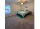 Bright bedroom with a ceiling fan, carpet, and a window offering natural light, creating a calming atmosphere at 404 Lennox W Rd # 404, Palm Harbor, FL 34683