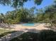 A spacious community pool is surrounded by lounge chairs and landscaping at 404 Lennox W Rd # 404, Palm Harbor, FL 34683