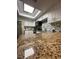 Bright kitchen features granite counters, white cabinets, tile backsplash, stainless steel appliances, and a skylight at 404 Lennox W Rd # 404, Palm Harbor, FL 34683