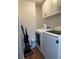 Laundry room features a side-by-side washer and dryer with overhead storage cabinets and hardwood floors at 404 Lennox W Rd # 404, Palm Harbor, FL 34683