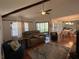 Living room features a vaulted ceiling with exposed beams, wood floors, a ceiling fan, and a dining area at 404 Lennox W Rd # 404, Palm Harbor, FL 34683