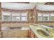 Bright bathroom features a soaking tub beneath large windows, wood cabinets, and floral wallpaper at 4309 W Robin Ln, Tampa, FL 33609