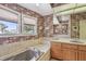 Relaxing bathroom showcasing a large tub under windows, a vanity area, and floral wallpaper at 4309 W Robin Ln, Tampa, FL 33609