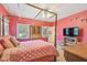 Bright bedroom with four-poster bed, natural light, and charming antique cabinet at 4309 W Robin Ln, Tampa, FL 33609