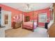 Bright pink bedroom featuring a four-poster bed, wooden furnishings, and lots of natural light at 4309 W Robin Ln, Tampa, FL 33609