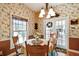 Dining room with floral wallpaper, a chandelier and natural light from two windows and glass doors at 4309 W Robin Ln, Tampa, FL 33609