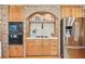 Kitchen featuring wood cabinets, stainless steel appliances, and a decorative brick archway at 4309 W Robin Ln, Tampa, FL 33609