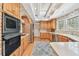 Cozy kitchen featuring wood cabinetry, stainless steel appliances, and a charming brick arch at 4309 W Robin Ln, Tampa, FL 33609