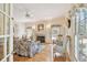Cozy living room with a fireplace, large windows, and hardwood flooring at 4309 W Robin Ln, Tampa, FL 33609