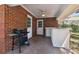 Covered brick patio featuring an outdoor kitchen space with a grill and white countertops with a mini fridge at 4309 W Robin Ln, Tampa, FL 33609