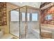Tiled walk-in shower with glass doors and a built-in bench, accented by floral wallpaper at 4309 W Robin Ln, Tampa, FL 33609