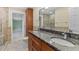 Bathroom with granite countertop, double sinks, tiled shower, and a door leading to the Primary bedroom at 4531 44Th S St, St Petersburg, FL 33711