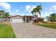 Charming home featuring a two-car garage, manicured lawn, and long, updated brick paver driveway at 4531 44Th S St, St Petersburg, FL 33711