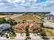 Aerial view of townhomes with manicured lawns, palm trees, and brick paved driveways at 4730 Wandering Way, Wesley Chapel, FL 33544
