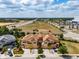 Aerial view of townhomes with manicured lawns, palm trees, and brick paved driveways at 4730 Wandering Way, Wesley Chapel, FL 33544