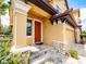 Close up of the front door, showing the covered porch, and stone veneer detail on the garage at 4730 Wandering Way, Wesley Chapel, FL 33544