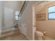 Hallway featuring a staircase and entry to a half bath with tile floors at 4730 Wandering Way, Wesley Chapel, FL 33544