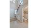Hallway featuring a staircase and entry to a half bath with tile floors and chandelier at 4730 Wandering Way, Wesley Chapel, FL 33544