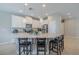 Bright kitchen features stainless steel appliances, large kitchen island with counter seating and pendant lighting at 4730 Wandering Way, Wesley Chapel, FL 33544