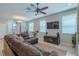 Enjoy a cozy living space with tile floors, a ceiling fan, and plenty of natural light from surrounding windows at 4730 Wandering Way, Wesley Chapel, FL 33544