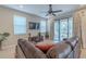 Comfortable living room with large couch, ceiling fan, and access to the outdoor patio through sliding glass doors at 4730 Wandering Way, Wesley Chapel, FL 33544
