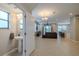 Open-concept living space with tile floors connects the living room, kitchen, and a convenient half-bathroom at 4730 Wandering Way, Wesley Chapel, FL 33544