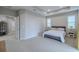 Spacious main bedroom with neutral carpet, tray ceiling, and ample natural light through large windows at 4730 Wandering Way, Wesley Chapel, FL 33544