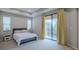 Bright main bedroom with tray ceilings, natural light and a sliding glass door to private balcony at 4730 Wandering Way, Wesley Chapel, FL 33544