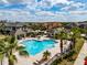Community pool with cabanas and lounge seating surrounded by palm trees at 4730 Wandering Way, Wesley Chapel, FL 33544