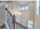 Elegant staircase with dark wood banister ascending to the upper level, illuminated by a modern chandelier at 4730 Wandering Way, Wesley Chapel, FL 33544