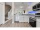 Modern kitchen featuring white cabinets, stainless steel appliances, and laminate flooring at 5084 Misty Canal Pl, Bradenton, FL 34203