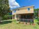 Large backyard featuring lush green grass, mature trees, landscaping, and a screened in patio at 5409 Fishhawk Ridge Dr, Lithia, FL 33547
