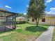 A view of the home's backyard featuring a mature shade tree and a screened in patio at 5409 Fishhawk Ridge Dr, Lithia, FL 33547