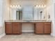 Bathroom featuring double vanity, granite countertops, a large mirror, and modern lighting fixtures over a tile floor at 5409 Fishhawk Ridge Dr, Lithia, FL 33547