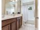 Well-lit bathroom featuring a double vanity, dark wood cabinets, a mirror, and a shower and tub combination at 5409 Fishhawk Ridge Dr, Lithia, FL 33547