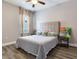 Bedroom featuring a bed with a padded headboard, wood-look floors, a ceiling fan and bright window at 5409 Fishhawk Ridge Dr, Lithia, FL 33547